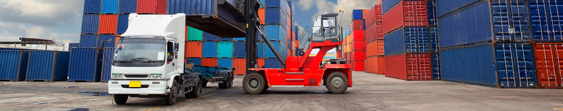 Shipping container port yard with trucks and forklifts